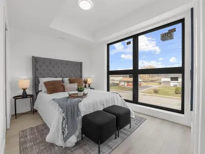 a bedroom with a bed and a large window at 2BR Penthouse Rooftop, Parking, Close to the Falls in Niagara Falls