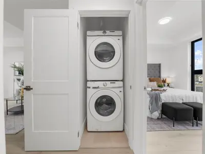 a room with a washer and dryer next to a bedroom at 2BR Penthouse Rooftop, Parking, Close to the Falls in Niagara Falls