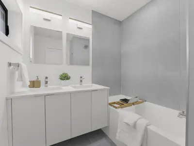 a white bathroom with a sink and a mirror at 2BR Penthouse Rooftop, Parking, Close to the Falls in Niagara Falls