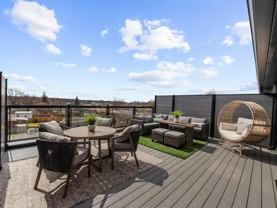 a patio with a table and chairs on a deck at 2BR Penthouse Rooftop, Parking, Close to the Falls in Niagara Falls