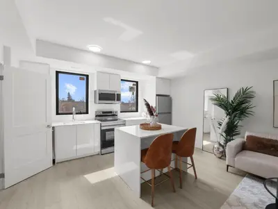 a kitchen with white cabinets and a table and chairs at 2BR Penthouse Rooftop, Parking, Close to the Falls in Niagara Falls