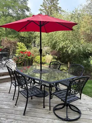 a table with a red umbrella on a deck at Charming private Guest Suite near Thermea Spa in Whitby