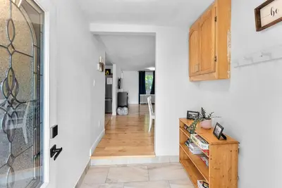 a hallway with white walls and a wooden cabinet at Cozy Family Retreat Minutes From the Falls and Pet Friendly in Niagara Falls