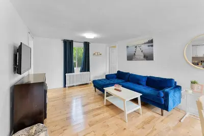 a living room with a blue couch and a table at Cozy Family Retreat Minutes From the Falls and Pet Friendly in Niagara Falls