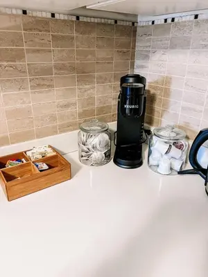 a coffee maker on a counter next to two jars at Cozy Family Retreat Minutes From the Falls and Pet Friendly in Niagara Falls