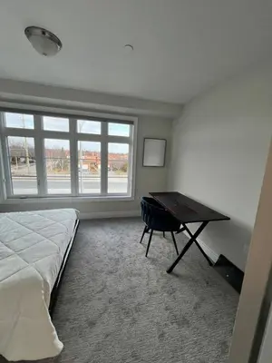a bedroom with a bed and a desk and a window at Modern Luxury Townhome with 2BR Balcony plus Parking - Happy Oaks in Oakville