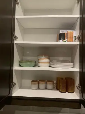 a cupboard with plates and bowls on it at Modern Luxury Townhome with 2BR Balcony plus Parking - Happy Oaks in Oakville