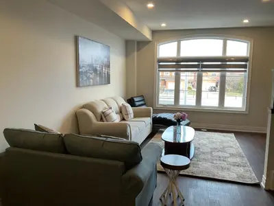 a living room with a couch and a table at Modern Luxury Townhome with 2BR Balcony plus Parking - Happy Oaks in Oakville