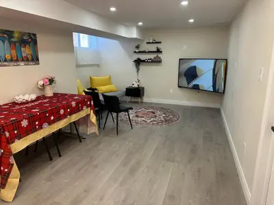 a living room with a dining table and a television at Newly Renovated and Spacious 3BR Private Apartment with 3 Baths & Parking in Richmond Hill