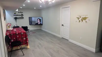 a room with a table and a television on a wall at Newly Renovated and Spacious 3BR Private Apartment with 3 Baths & Parking in Richmond Hill