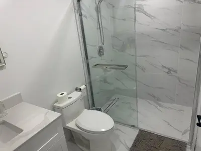 a bathroom with a toilet and a glass shower at Newly Renovated and Spacious 3BR Private Apartment with 3 Baths & Parking in Richmond Hill