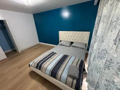 a bedroom with a bed with a blue wall at Private Room Near Airport D12 in Mississauga