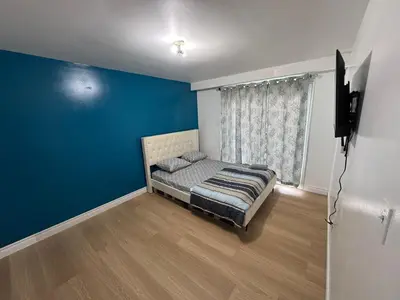 a bedroom with a bed and a blue wall at Private Room Near Airport D12 in Mississauga