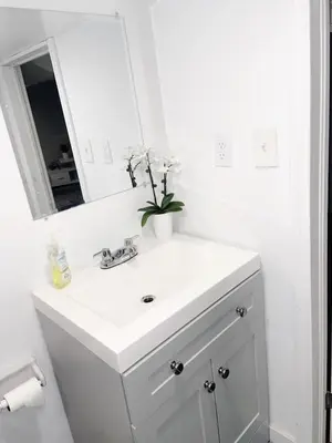 a white bathroom with a sink and a mirror at ClassicPavillion INN in Bowmanville