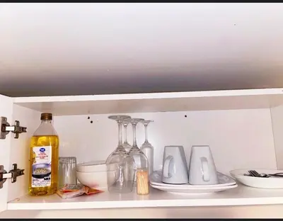 a shelf with glass bottles and plates on it at ClassicPavillion INN in Bowmanville
