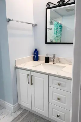 a bathroom with a white sink and a mirror at Modern 2BR Basement Suite Private Entrance in Brampton