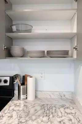 a kitchen counter with plates and bowls on a shelf at Modern 2BR Basement Suite Private Entrance in Brampton
