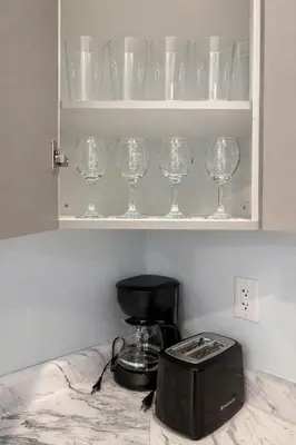 a row of wine glasses on a shelf in a kitchen at Modern 2BR Basement Suite Private Entrance in Brampton