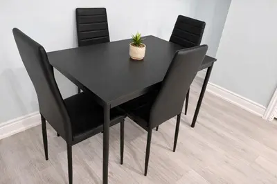 a black dining table and chairs with a plant on it at Modern 2BR Basement Suite Private Entrance in Brampton