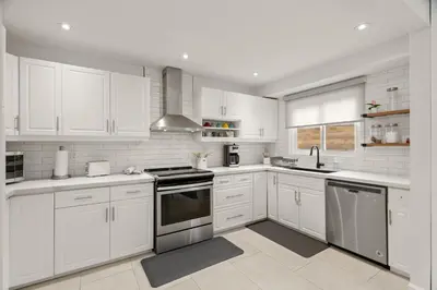 a white kitchen with white cabinets and stainless steel appliances at 4BR Family Home - Dog-Friendly, Huge Yard, 5 Beds in Pickering