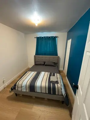 a small bedroom with a bed with a blue wall at Private Room Near Airport D34 in Mississauga