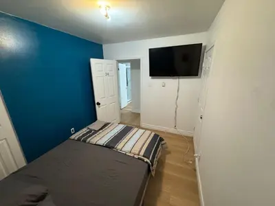 a bedroom with a bed and a blue wall at Private Room Near Airport D34 in Mississauga