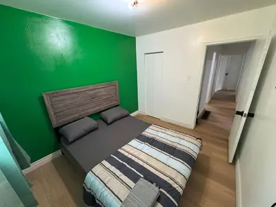 a bedroom with a green wall and a bed at Private Room Near Airport D50 in Mississauga