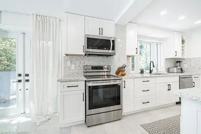 a white kitchen with a stove and a microwave at Licensed-8 Acre Estate, Trail & Stream with 3 Beds in Hamilton