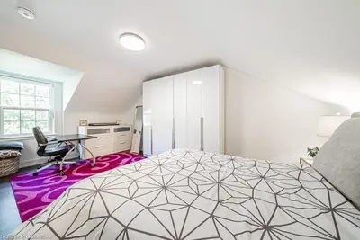 a bedroom with a large bed with a purple rug at Licensed-8 Acre Estate, Trail & Stream with 3 Beds in Hamilton
