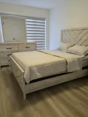 a bedroom with a large bed with a dresser and a mirror at Modern 3BR FriendlyTown Home in Paris