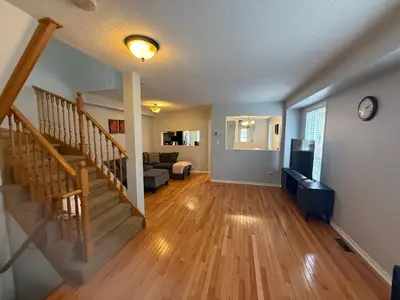 a living room with a staircase and a couch at Spacious Three Bedroom House Wifi Parking in Milton