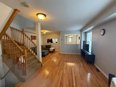 a living room with a staircase and a couch at Spacious Three Bedroom House Wifi Parking in Milton