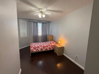 a small bedroom with a bed and a ceiling fan at Spacious Three Bedroom House Wifi Parking in Milton
