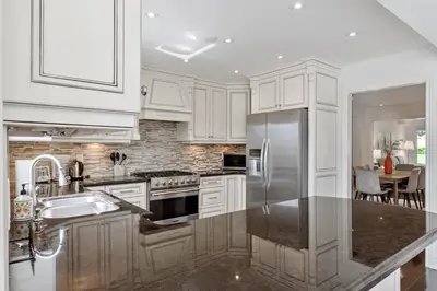 a kitchen with white cabinets and a stainless steel refrigerator at Modern 4BR Retreat with Premium Comforts & Parking in Richmond Hill