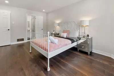 a bedroom with a white bed and a wooden floor at Modern 4BR Retreat with Premium Comforts & Parking in Richmond Hill
