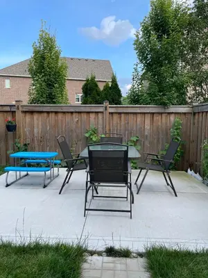 a patio with a table and chairs and a fence at One bedroom and studio Basement Apartment unit sleeps 4 in Oakville