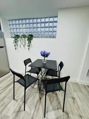 a table and chairs with a vase of flowers on it at The Urban Executive Suite - Premier Kitchener Loft in Kitchener