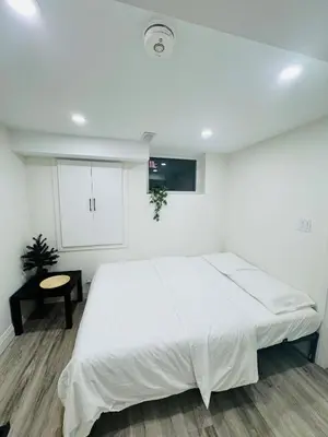 a white bedroom with a large bed and a table at The Urban Executive Suite - Premier Kitchener Loft in Kitchener