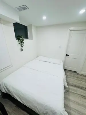 a white bedroom with a white bed and a window at The Urban Executive Suite - Premier Kitchener Loft in Kitchener