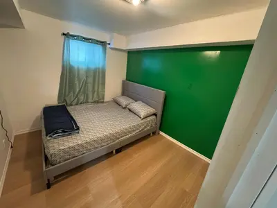 a small bed in a room with a green wall at Private Room Near Airport D39 in Mississauga
