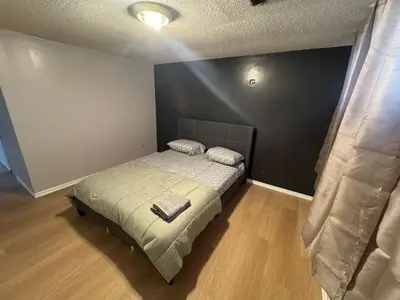 a bedroom with a bed and a black wall at Private Room Near Airport D89 in Mississauga