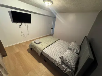 a bedroom with a bed and a flat screen tv at Private Room Near Airport D89 in Mississauga