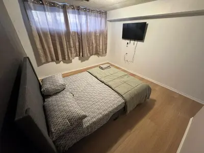 a small bedroom with a bed and a tv at Private Room Near Airport D89 in Mississauga