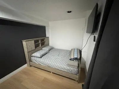 a small bedroom with a bed and a television at Private Room Near Airport D90 in Mississauga