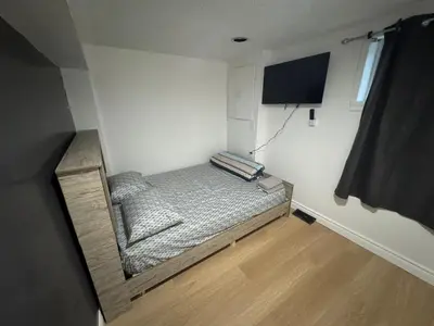 a small bedroom with a bed and a mirror at Private Room Near Airport D90 in Mississauga
