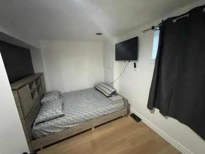a small bedroom with a bed and a television at Private Room Near Airport D90 in Mississauga