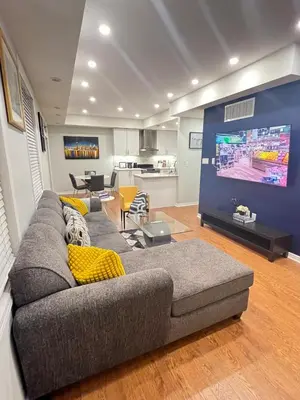 a living room with a couch and a large tv at Peaceful serene oasis with free parking and wifi in Brampton