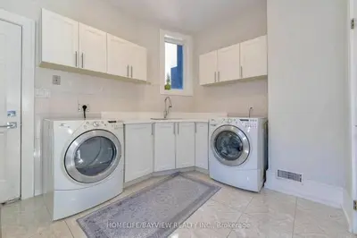 a laundry room with two washing machines and a sink at Luxury Modern Retreat in Richmond Hill in Richmond Hill