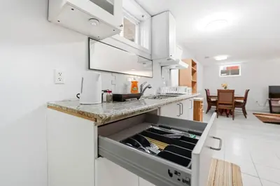 a white kitchen with a sink and a counter at Tranquil Bliss Retreat 9 min to Falls with Free Parking in Niagara Falls