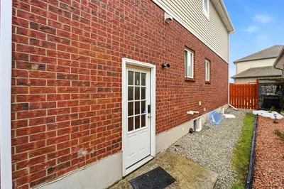 a brick building with a white door on it at Tranquil Bliss Retreat 9 min to Falls with Free Parking in Niagara Falls